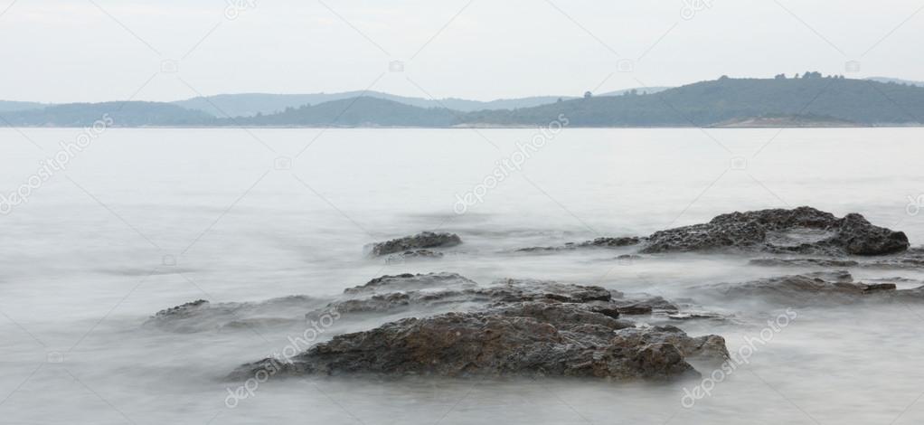 Sanfte Brandung an Felsküste minimalistisch komponiert